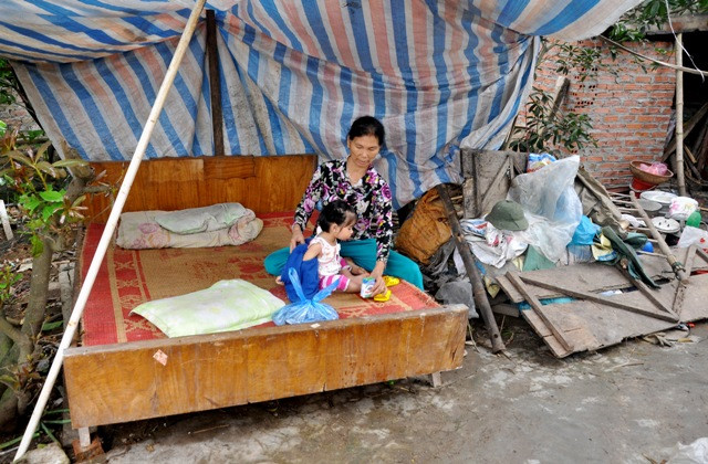 Chiếc giường nhỏ được đặt ngoài vườn là nơi ở hiện tại của gia đình nhà bà Vị. Bởi nỗi lo nguy hiểm do nhà nứt gãy bất cứ lúc nào.