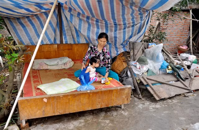 Chiếc giường nhỏ được đặt ngoài vườn là nơi ở hiện tại của gia đình nhà bà Vị. Bởi nỗi lo nguy hiểm do nhà nứt gãy bất cứ lúc nào.