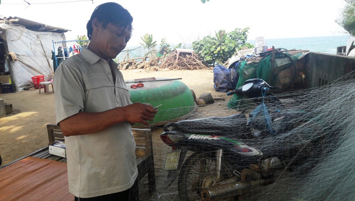 Lão ngư Trương Đình Kiểm (thông An Cường, xã Bình Hải, Bình Sơn) cặm cụi may lại tấm lưới để chuẩn bị cho chuyến biển đêm. Gia đình ông mấy đời đi biển, sống nhờ biển, nay lại đứng trước cảnh có thể bị &quot;cách ly&quot; với biển vì &quot;đại dự án khủng&quot; của Tập đoàn FLC.