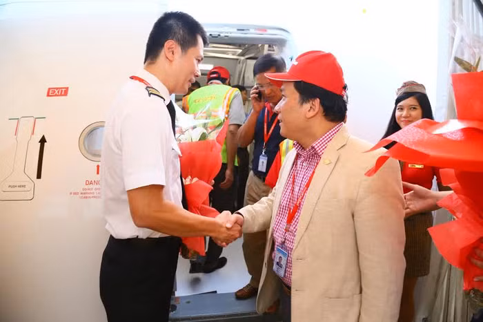 Ông Đinh Việt Phương - Phó Tổng Giám đốc Vietjet (dội mũ đỏ bên phái hình) chúc mừng phi hành đoàn