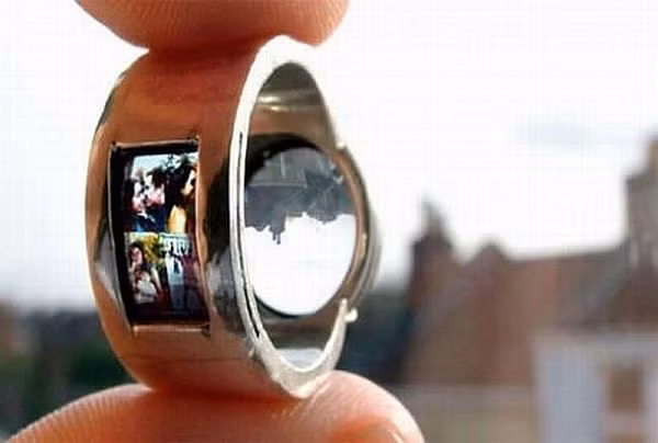1. Nhẫn cưới máy chiếu - Projector wedding ring Dưuọc thiết kế bởi Luke Jerram và nhà thiết kế trang sức Tamrakar, chiếc nhẫn máy chiếu này là sự sáng tạo đầy khéo léo với ,màn hình slide sáng rõ và một thấu kính nhỏ. Jerram đã đặt những bức hình nhỏ của anh với người yêu vào trong màn hình chiếu nhỏ và hình ảnh này sẽ được hiện lên rõ nét do ánh sáng phản chiếu qua thấu kính. Tuy nhiên, nhà thiết kế Jerram lại không có ý định tạo ra chiếc thứ hai giống món hàng độc này trước mọi yêu cầu của những người cũng muốn sở hữu nó.