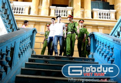 Dẫn giải bị cáo Hoàng (đi trước) và bị cáo Nam tại tòa.