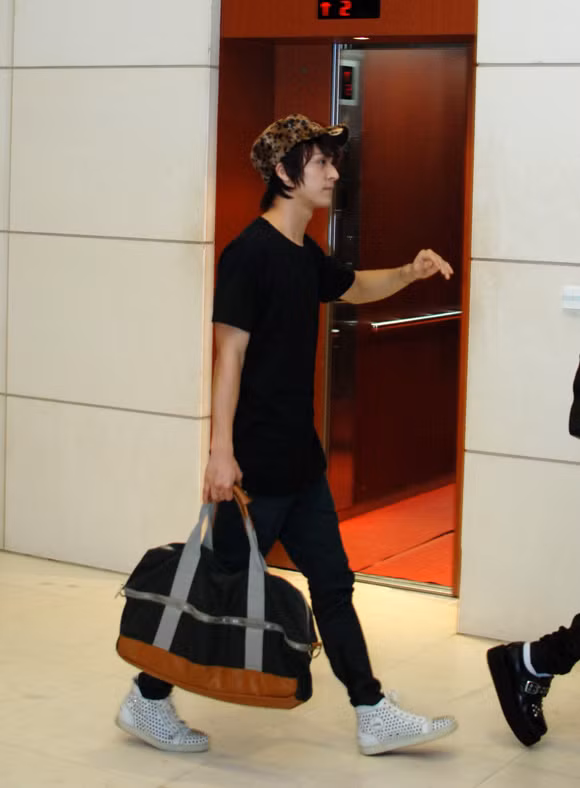 Dong Woon (Beast) thời trang với mũ da báo và túi xách tiện dụng.