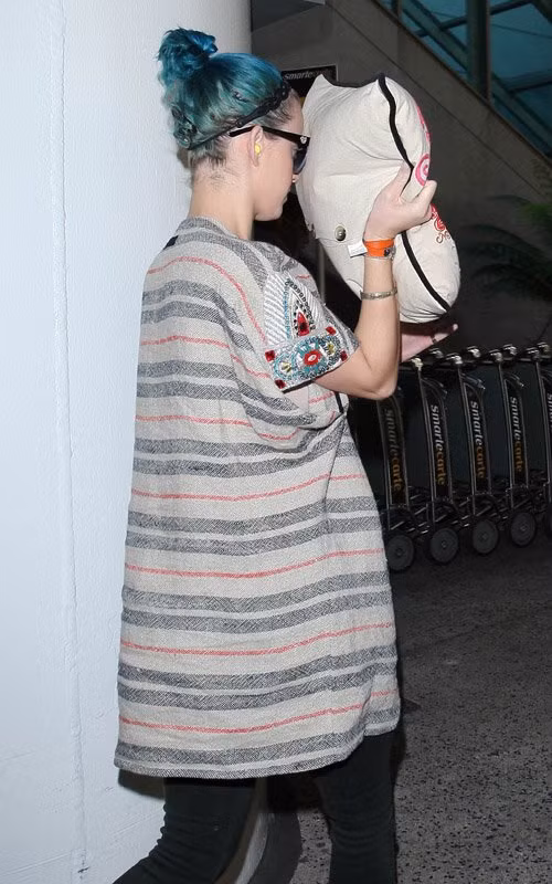 Katy Perry dùng chiếc gối lưu niệm của Paris và che kín mặt mình suốt cả chặng đường ở sân bay.