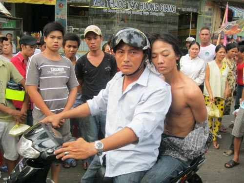 Hiệp sĩ Nguyễn Văn Minh Tiến (người cầm lái) đưa đối tượng cướp giật là Nguyễn Ngọc Châu về cơ quan Công an (Ảnh NLDO)