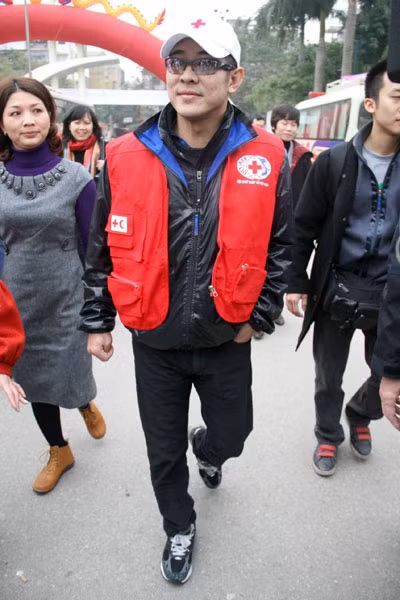 Trong trang phục giản dị: áo, mũ đồng phục của Hội chữ thập đỏ, giày thể thao, đeo kính đen, Lý Liên Kiệt luôn nở nụ cười rất thân thiện, gần gũi với mọi người.(Ảnh: Thể thao văn hóa)