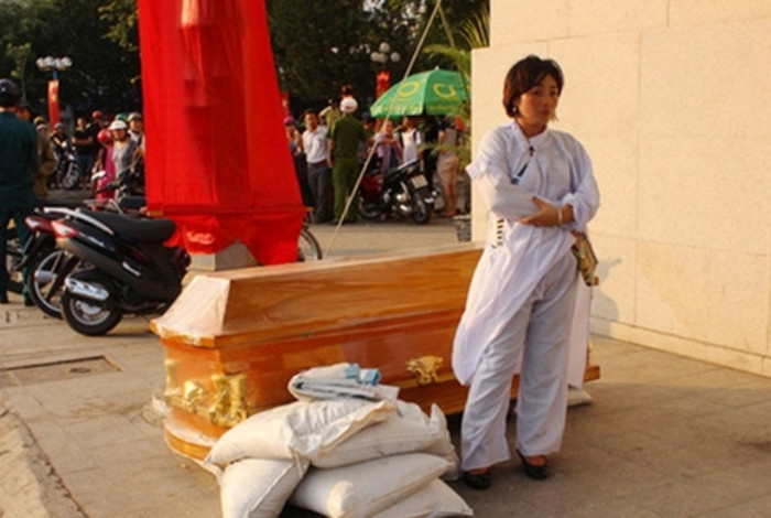 Bà Long đưa quan tài đến trước Ngân hàng TMCP Nam Á chi nhánh Nha Trang (ảnh nguồn CAND) Bà Long đưa quan tài đến trước Ngân hàng TMCP Nam Á chi nhánh Nha Trang (ảnh nguồn CAND)