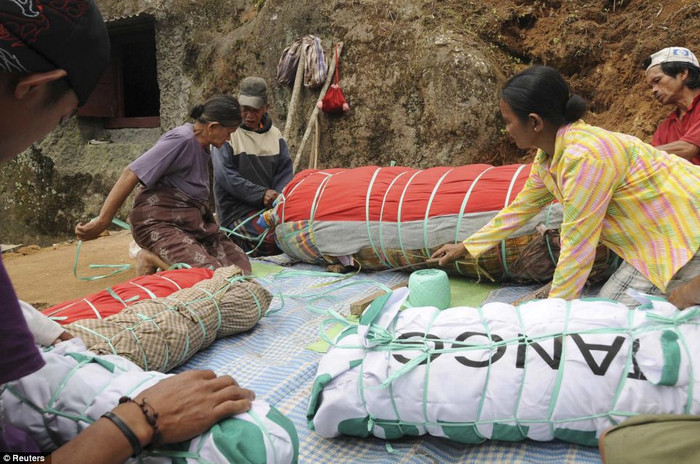 Người dân làng đang cuộn những tấm vải xung quanh xác ướp phía trước ngôi mộ đá Liang Người dân làng đang cuộn những tấm vải xung quanh xác ướp phía trước ngôi mộ đá Liang