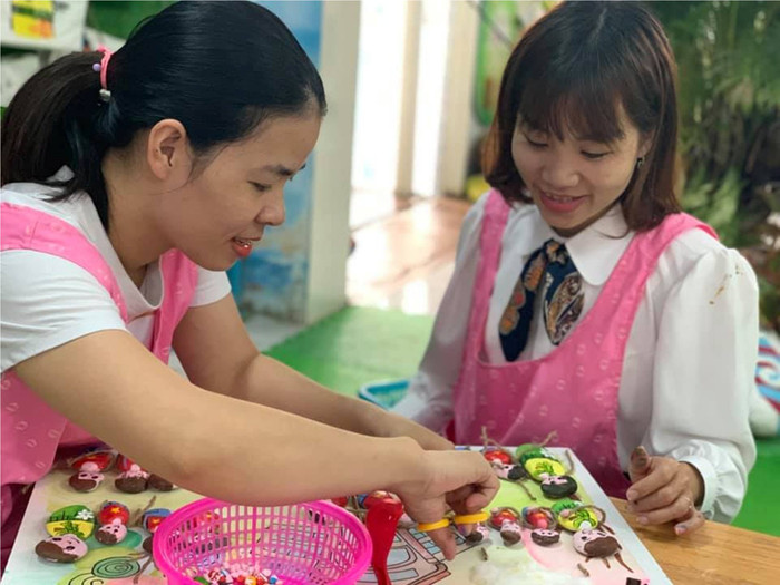 Các cô giáo cẩn thận chỉnh sửa những bức tranh bằng đá cho học sinh.