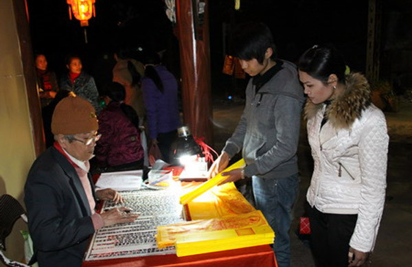 Những ngày đầu năm, người dân nô nức đi chùa chiền cầu may, cầu lộc cho một năm mới bình an, hạnh phúc. Ở đâu cũng vậy, ngay từ ngoài cổng chùa đã thấy cảnh người đi lễ tấp nập. Dịch vụ viết sớ trở nên đắt khách khi nhiều người ngồi xếp hàng chờ đến lượt viết sớ cầu may. (Ảnh: Thainguyen)