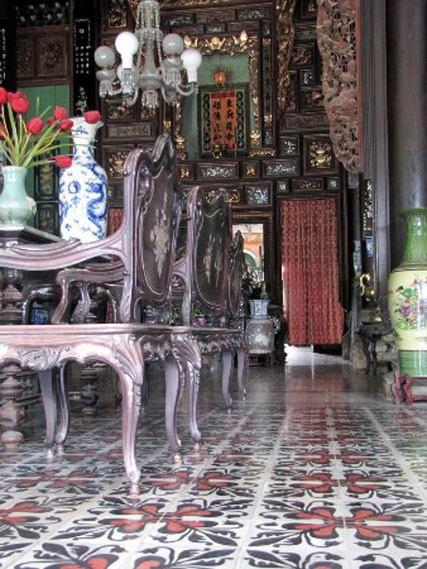 Bộ bàn tiếp khách bằng gỗ lim với chi tiết rồng phụng được chạm, khắc điêu luyện. Để có bộ ghế bằng gỗ lim này một nghệ nhân người miền Nam đã phải chạm các chi tiết rồng phụng chính xác đến từng milimet một. Bộ ghế lớn là vậy, nặng là vậy nhưng chân ghế chỉ nhỏ bằng cổ tay em bé. Riêng thợ cẩn xà cừ lại là một nghệ nhân miền Bắc nổi danh thời đó đảm trách. Trải qua hơn trăm năm nay nhưng những vẩy xà cừ cứ óng ánh ngũ sắc rực rỡ.