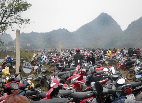 Bãi đỗ xe vào chùa Bái Đính chật kín người. Những hàng xe nối dài tít tắp. Khó khăn lắm, nhóm phóng viên báo điện tử Giáo Dục Việt Nam mới tìm được cho mình một chỗ dựng xe còn trống. Đại diện ban quản lý bãi gửi xe cho biết: “Ngày nào cũng nườm nượp khách ra vào, hôm nay (mùng 6 Tết – pv), chưa kể lượng ô tô, chỉ tính riêng số xe máy cũng đã ngót nghét 10.000 xe tới thăm viếng chùa”.