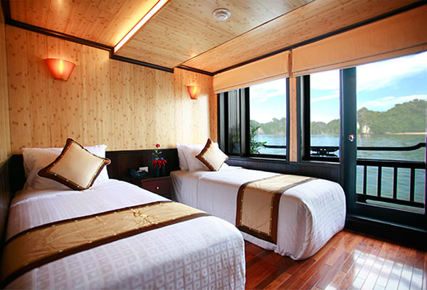 Tất cả các phòng đều có view nhìn ra biển, được thiết kế bằng gỗ hương và các chi tiết nội thất được chạm khắc hoàn toàn bằng tay. Chỉ cần kéo tấm rèm cửa lên, bạn có thể vừa nằm dài thảnh thơi trên giường vừa ngắm nhìn vịnh Hạ Long mênh mông sóng nước phía ngoài xa.