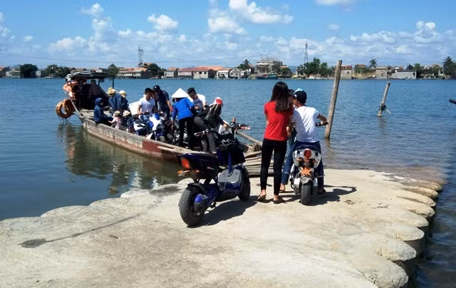 Mỗi lần có việc sang sông, người dân phải mang cả xe lẫn người lên thuyền (Ảnh: Thủy Phan)