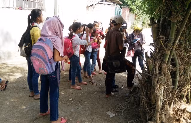 Giờ tan học, mỗi tốp học sinh đứng dưới gốc tre chờ đò đến (Ảnh: Thủy Phan)