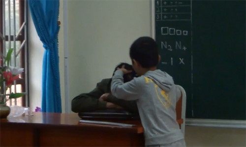 Cảnh thầy Nguyễn Như Tưởng, giáo viên dạy môn Thủ Công tại lớp 2A trong giờ học gục trên bàn được một nam sinh lên thoa dầu, nhổ tóc bạc (Ảnh cắt từ clip) Cảnh thầy Nguyễn Như Tưởng, giáo viên dạy môn Thủ Công tại lớp 2A trong giờ học gục trên bàn được một nam sinh lên thoa dầu, nhổ tóc bạc (Ảnh cắt từ clip)