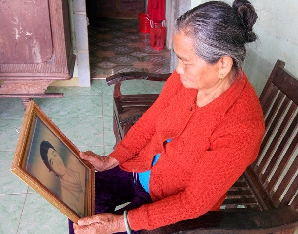 Mẹ của liệt sỹ Trương Minh Thương cầm di ảnh con trên tay rưng rưng nước mắt (Ảnh: Thủy Phan) Mẹ của liệt sỹ Trương Minh Thương cầm di ảnh con trên tay rưng rưng nước mắt (Ảnh: Thủy Phan)