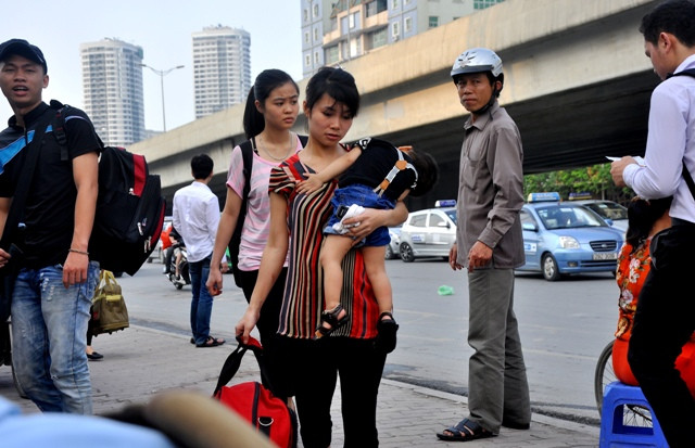 Tay xách, tay bồng con, người mẹ này đang đi về phía bến xe để bắt thêm một chuyến xe nữa. Tay xách, tay bồng con, người mẹ này đang đi về phía bến xe để bắt thêm một chuyến xe nữa.