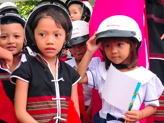 Học sinh người Cơ Tu vui vẻ nhận mũ bảo hiểm trong ngày khai giảng. Học sinh người Cơ Tu vui vẻ nhận mũ bảo hiểm trong ngày khai giảng.