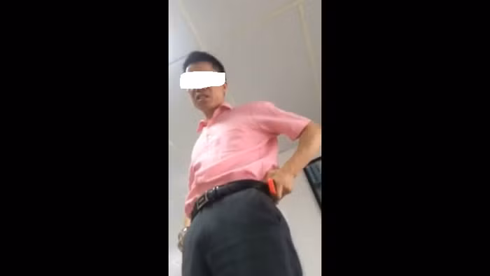 Người được cho là ông Phạm Văn H. đứng trên bàn chống nạnh chửi bới (ảnh chụp từ video).