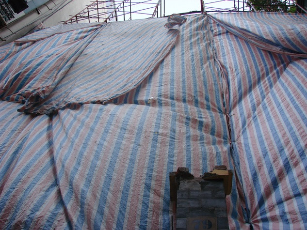 Nhìn từ dưới chỉ thấy những dàn giáo bắc vút lên trên để phục vụ việc phá dỡ căn nhà