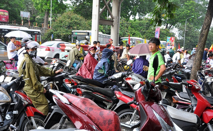 Mưa gió làm đường xá nhếch nhác khiến nhiều phụ huynh gặp khó khăn và thấy khó chịu khi phải mặc áo mưa lòa xòa khi đứng đợi con.