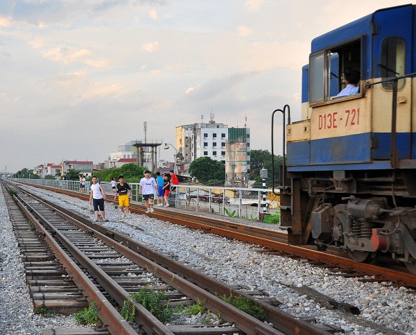 Một nhóm thanh niên thản nhiên đi lại trên đường ray khi tàu đang chạy tới. Đây là những hành động coi thường sự nguy hiểm của nhiều người nơi đây.