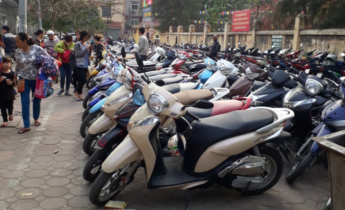 Mặc dù giấy phép tạm ghi rất rõ trong giờ cao điểm không được trông giữ xe nhưng quan sát của phóng viên có mặt 16h30 tại đây, bãi xe này vẫn có hàng trăm chiếc được dựng trên vỉa hè, gây cản trở cho người đi đường và phụ huynh đến đón con. Ảnh Trần Việt. Mặc dù giấy phép tạm ghi rất rõ trong giờ cao điểm không được trông giữ xe nhưng quan sát của phóng viên có mặt 16h30 tại đây, bãi xe này vẫn có hàng trăm chiếc được dựng trên vỉa hè, gây cản trở cho người đi đường và phụ huynh đến đón con. Ảnh Trần Việt.