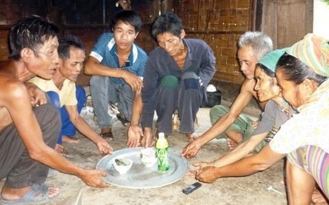 Mọi người vây quanh bên mâm lễ để chứng kiến lễ cúng vía cho người bệnh. Ky la vuot dao nung, ngam lua... duoi benh