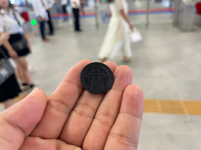 Thẻ đi tàu của đường sắt Nhổn - Ga Hà Nội có hình tròn, nhỏ như đồng xu và bên trên có hình ảnh Khuê Văn Các - biểu tượng của Hà Nội. GDVN_10.jpg