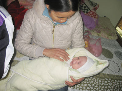 Cháu Phạm Xuân Hà bên người bác họ trong ngày lễ đầy tháng "muộn" 11/12. Cháu Phạm Xuân Hà bên người bác họ trong ngày lễ đầy tháng "muộn" 11/12.