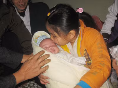 Bé Hà bên vòng tay của chị gái cháu.