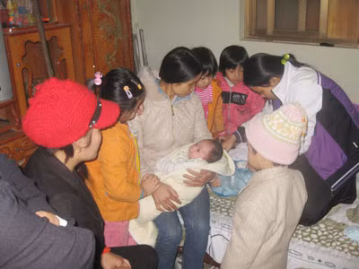 Bé Hà bên bà con họ hàng trong ngày đầy tháng "muộn".