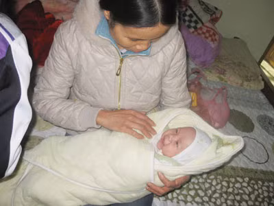 Bé Phạm Trường Hà bên vòng tay của người bác họ vào sáng 11.12