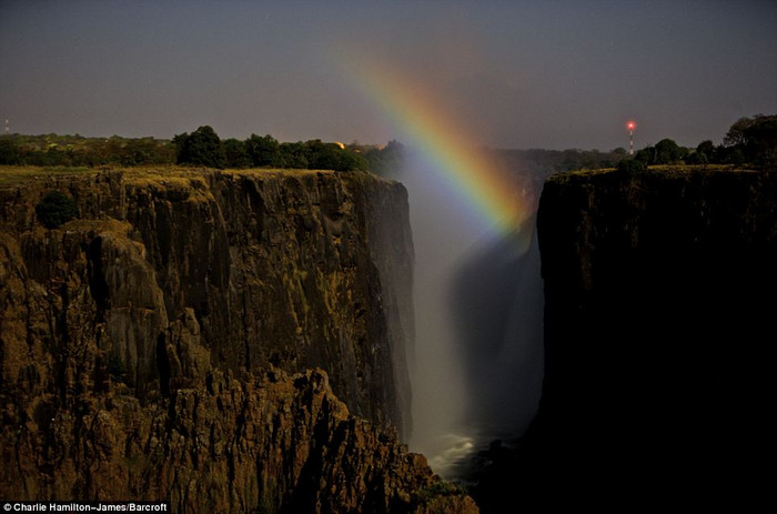 Victoria Falls còn đươc gọi với cái tên “ khói sấm”. Thác bắt nguồn từ dòng chảy của vùng nước bình lặng sông Zambezi, ồi nước đột ngột rơi tự do hơn 100 mét (330 feet) xuống phía dưới vực đá tạo nên khung cảnh hung vĩ nơi đây, tạo ra sương và âm thanh như sấm. Thác cuồn cuộn đổ như mưa như bão xuống hàng trăm m3 nước mỗi giây, nước cuộn trắng xóa giữa núi ngàn và rền vang hàng km. Và đây chính là điều kiện thuận lợi làm xuất hiện ánh cầu vồng tuyệt đẹp cả ngày lẫn đêm. Victoria Falls còn đươc gọi với cái tên “ khói sấm”. Thác bắt nguồn từ dòng chảy của vùng nước bình lặng sông Zambezi, ồi nước đột ngột rơi tự do hơn 100 mét (330 feet) xuống phía dưới vực đá tạo nên khung cảnh hung vĩ nơi đây, tạo ra sương và âm thanh như sấm. Thác cuồn cuộn đổ như mưa như bão xuống hàng trăm m3 nước mỗi giây, nước cuộn trắng xóa giữa núi ngàn và rền vang hàng km. Và đây chính là điều kiện thuận lợi làm xuất hiện ánh cầu vồng tuyệt đẹp cả ngày lẫn đêm.