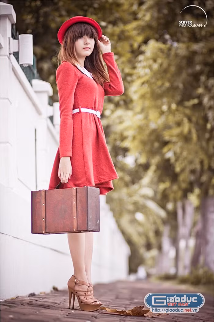 Chiếc váy liền thân màu đỏ tươi tắn, nổi bật cổ ren trắng mix cùng thắt lưng bản nhỏ tạo nét trẻ trung, đáng yêu