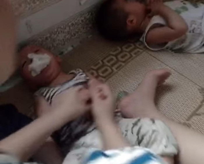 Hình ảnh cháu bé bị nhét giẻ vào miệng cắt từ clip trên mạng xã hội (ảnh: VOV)