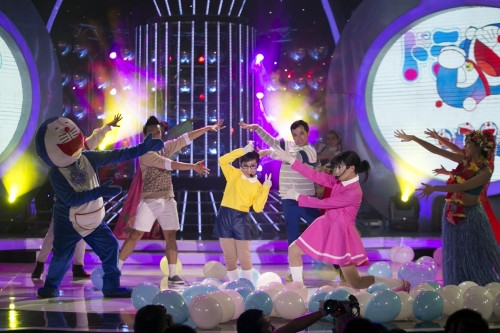 Từng xuất sắc trong các vai giả gái trong phiên bản người lớn, thế nhưng Minh Thuận lại chấp nhận thiệt thòi khi lu mờ hơn để giúp tiết mục của thí sinh nhí Anh Duy tỏa sáng. Giọng hát mạnh mẽ, tự nhiên của em đã đưa khán giả quay trở về tuổi thơ với câu chuyện đáng yêu về Đoraemon và những người bạn dễ thương của mình.