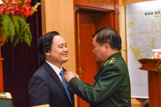 Bộ trưởng Phùng Xuân Nhạ nhận kỷ niệm chương “Vì chủ quyền an ninh biên giới Tổ quốc” (Ảnh: Bộ Giáo dục và Đào tạo)