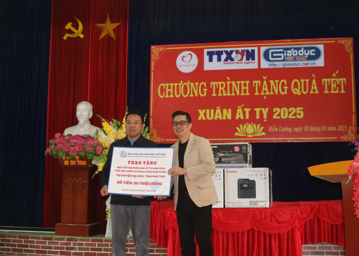 Ông Nguyễn Duy Hùng - Phó Tổng Giám đốc Công ty Cổ phần Đầu tư và Phát triển Giáo dục Hà Nội (bên phải) trao tặng quà cho các em học sinh có hoàn cảnh khó khăn trên địa bàn xã Hiền Lương. xã Hiền Lương 5.JPG