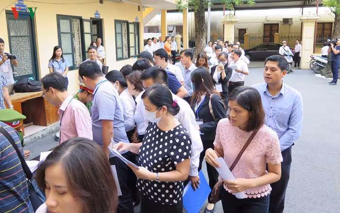 Các đương sự xếp hàng dài làm thủ tục để được tham dự phiên tòa (ảnh vov.vn).