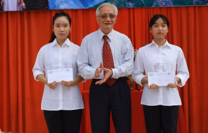 Thầy Tùng Lâm thay mặt Nhà trường vinh danh và trao học bổng cho hai học sinh khối 10 có điểm đầu vào cao nhất.