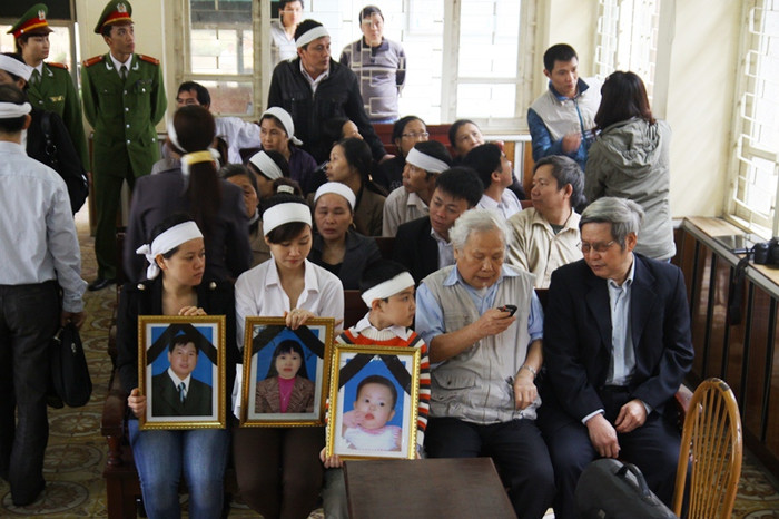 Người nhà bị hại đeo khăn tang và mang di ảnh những người quá cố đến dự phiên xử Người nhà bị hại đeo khăn tang và mang di ảnh những người quá cố đến dự phiên xử