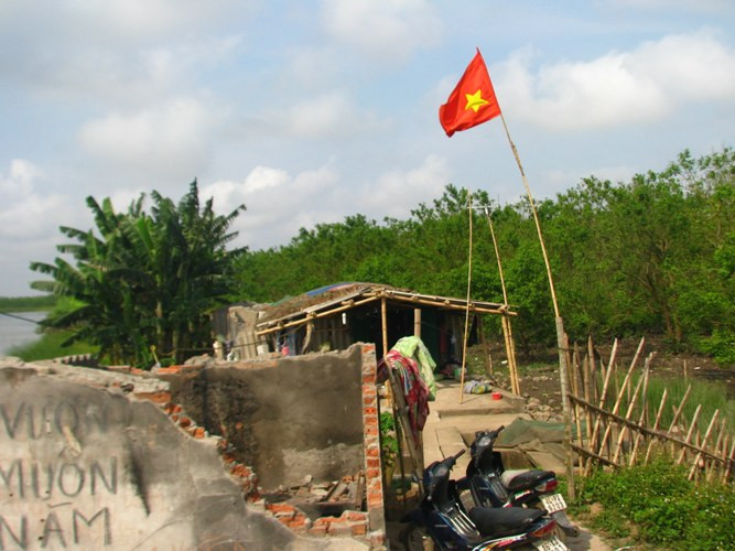 Trước cổng, lá cờ Tổ quốc vẫn tung bay phấp phới, như một sự thể hiện lòng yêu nước, lòng tin vào Đảng và Chính phủ. Trước cổng, lá cờ Tổ quốc vẫn tung bay phấp phới, như một sự thể hiện lòng yêu nước, lòng tin vào Đảng và Chính phủ.