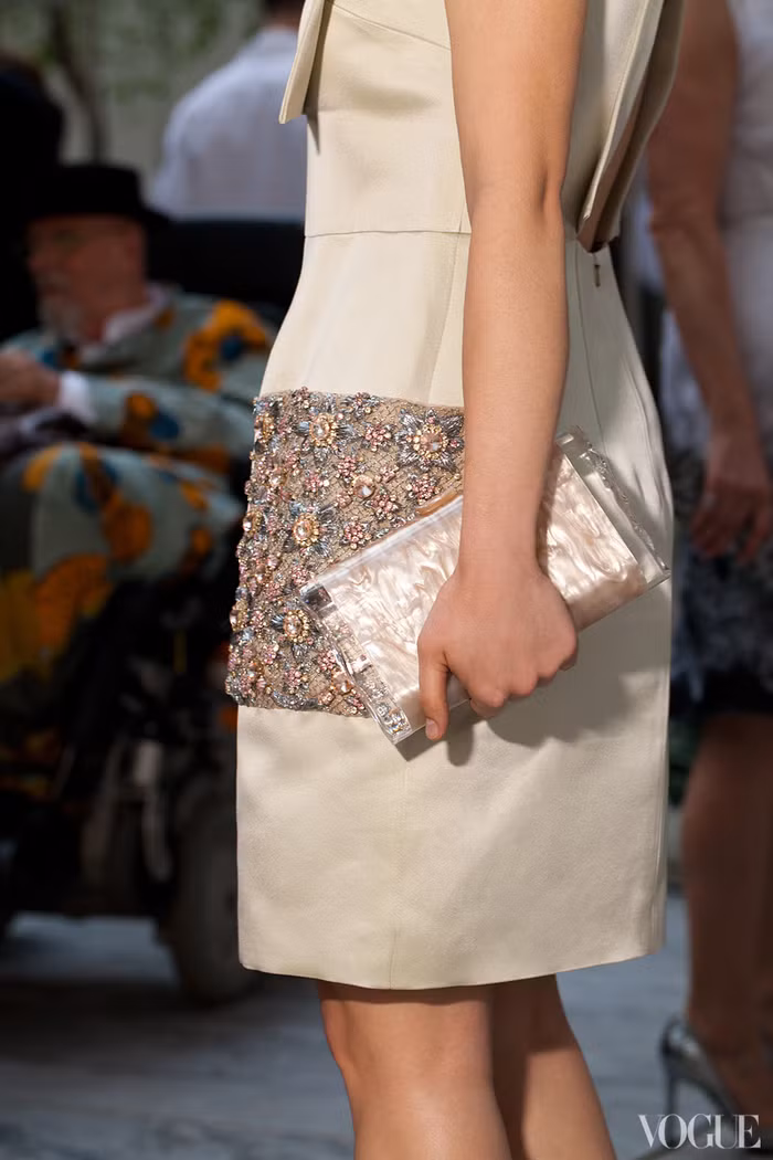 Chiếc váy có phần họa tiết cực nổi ở phần hông váy, thế nên cô đã không sử dụng thêm bất kì món đồ trang sức nào và kết hợp chiếc ví cầm tay đơn giản đồng tông với váy