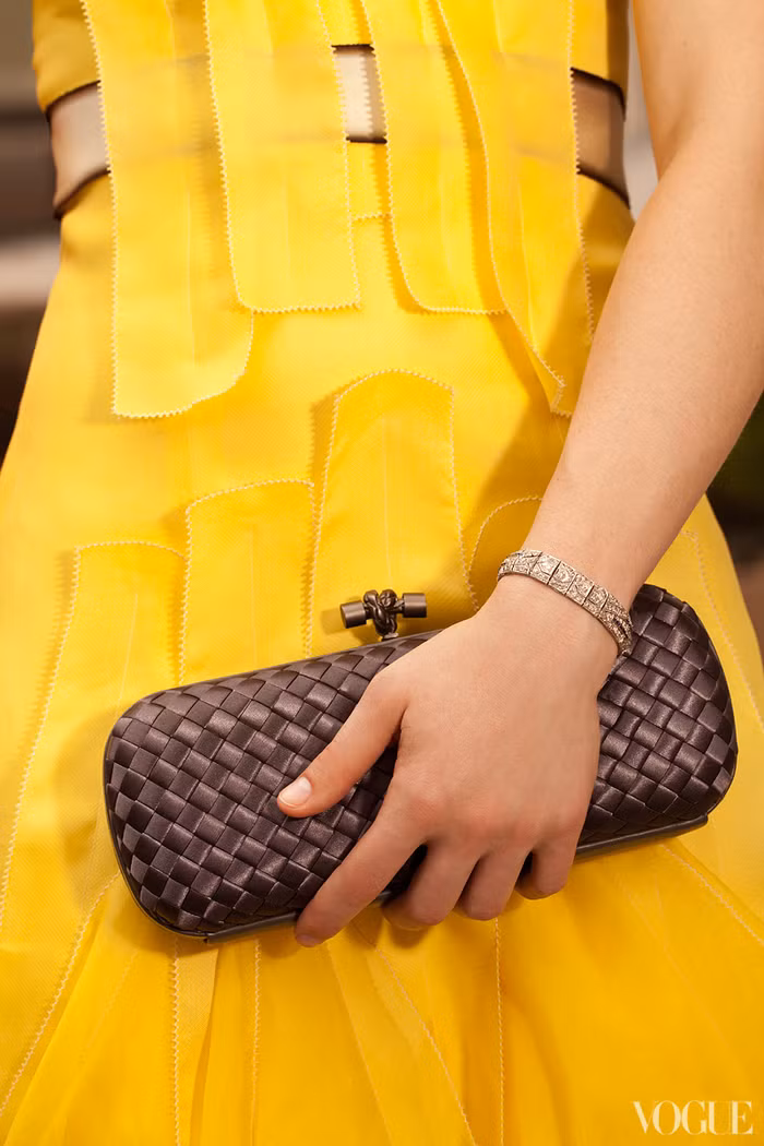 Kết hợp với chiếc ví nhỏ cầm tay màu đồng