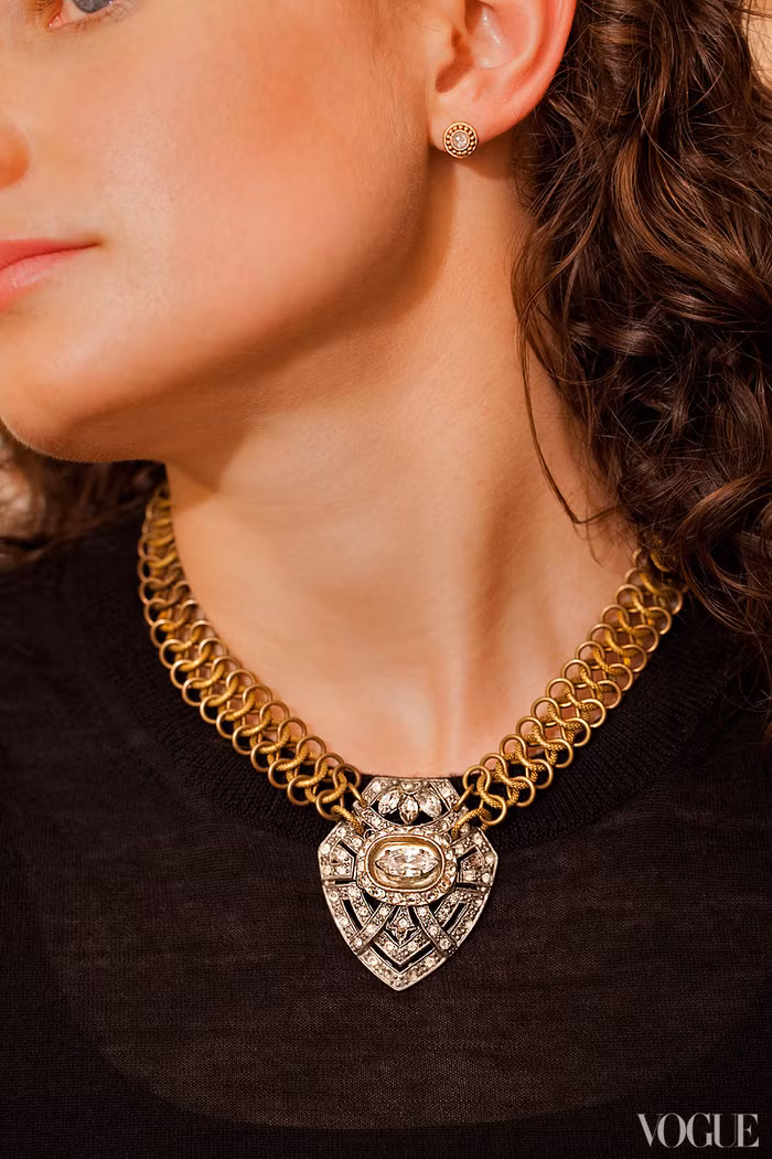 Trên nền áo thun đen đơn giản, nổi bật là chiếc vòng cổ với họa tiết thật cầu kì