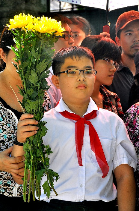 Khoắc trên mình bộ đồng phục học sinh có quàng khăn đỏ và cầm bó hoa tươi, em Nguyễn Hoàng Phúc (lớp 6, trường THCS Giáp Bát) cùng mẹ thành kính đến viếng hương hồn Đại tướng.