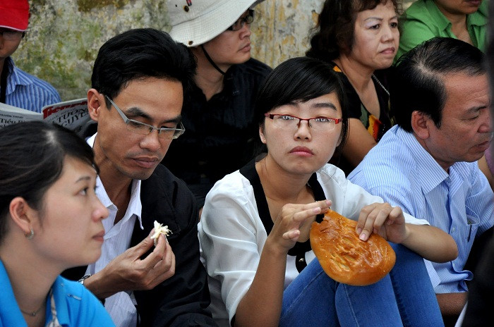 Đến giờ nghỉ trưa, mọi người ăn uống tại chỗ mà không rời hàng