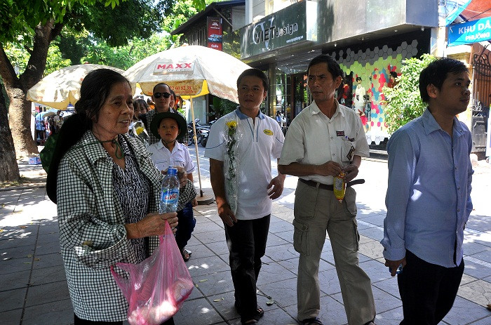 Bà Nguyễn Thị Trọng, 71 tuổi đang cùng các con phát bánh mỳ và nước uống miễn phí cho đồng bào xếp hàng vào viếng Đại tướng.